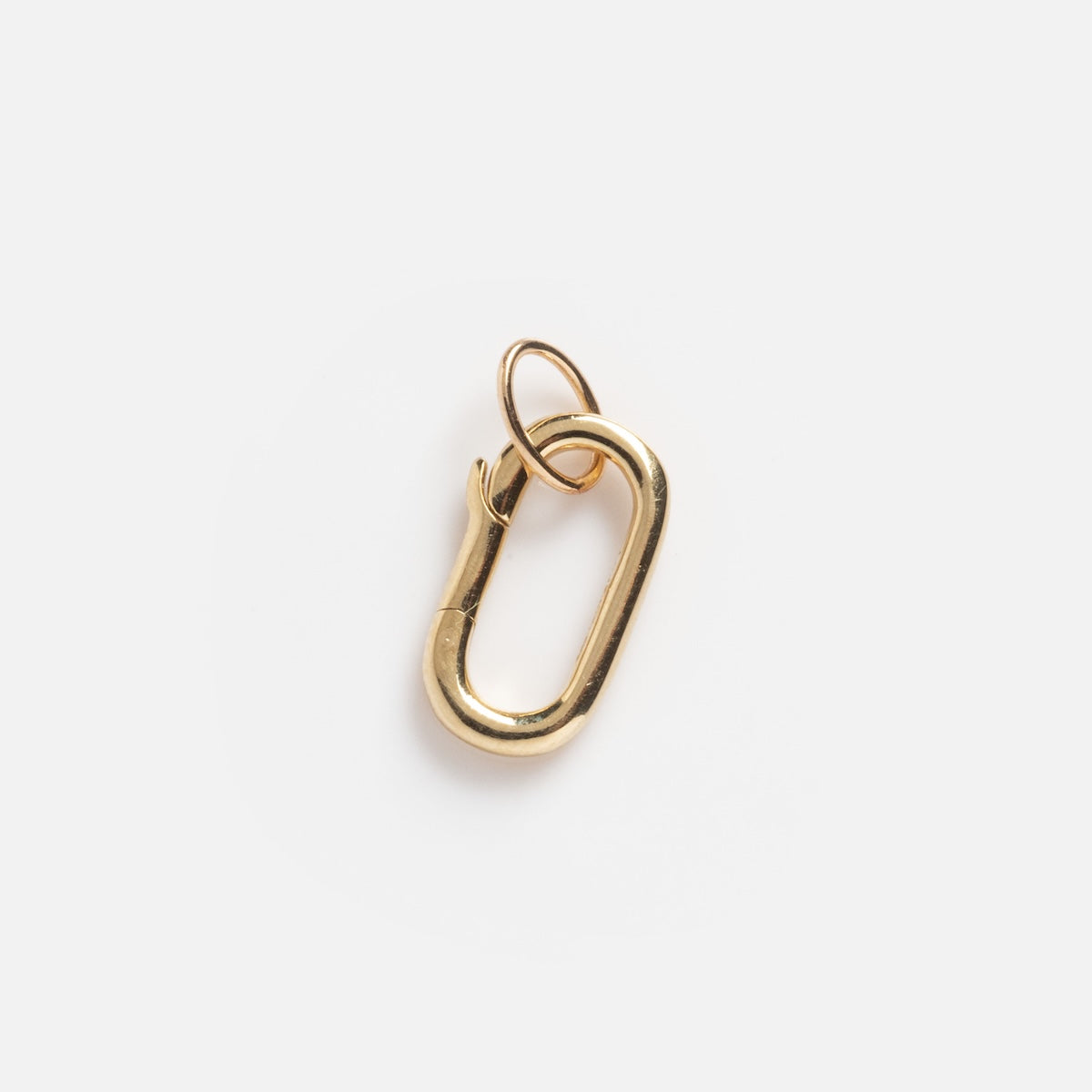 The Solid Gold Oval Charm Clip Sample is a small, gold oval carabiner with a looped ring, shown against a plain white background.