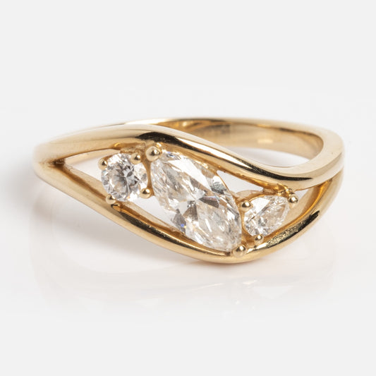 The Solid Gold Floating Diamond Wave Ring (Sample Size 7) features a modern open band in 14k yellow gold, with three lab diamond gemstones of various shapes set diagonally across the center.