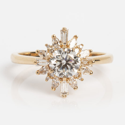 The Solid Gold Diamond Starburst Ring Sample Size 7 features a 14k yellow gold band with a round, brilliant-cut central diamond, accented by marquise and baguette diamonds in a starburst design. Also available with a lab diamond center for ethical sparkle.