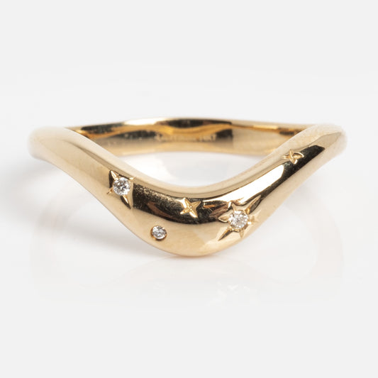 The Solid Gold Diamond Curve Band Sample Size 7 is a 14k yellow gold V-shaped ring with three small lab diamonds and star-shaped front engravings.