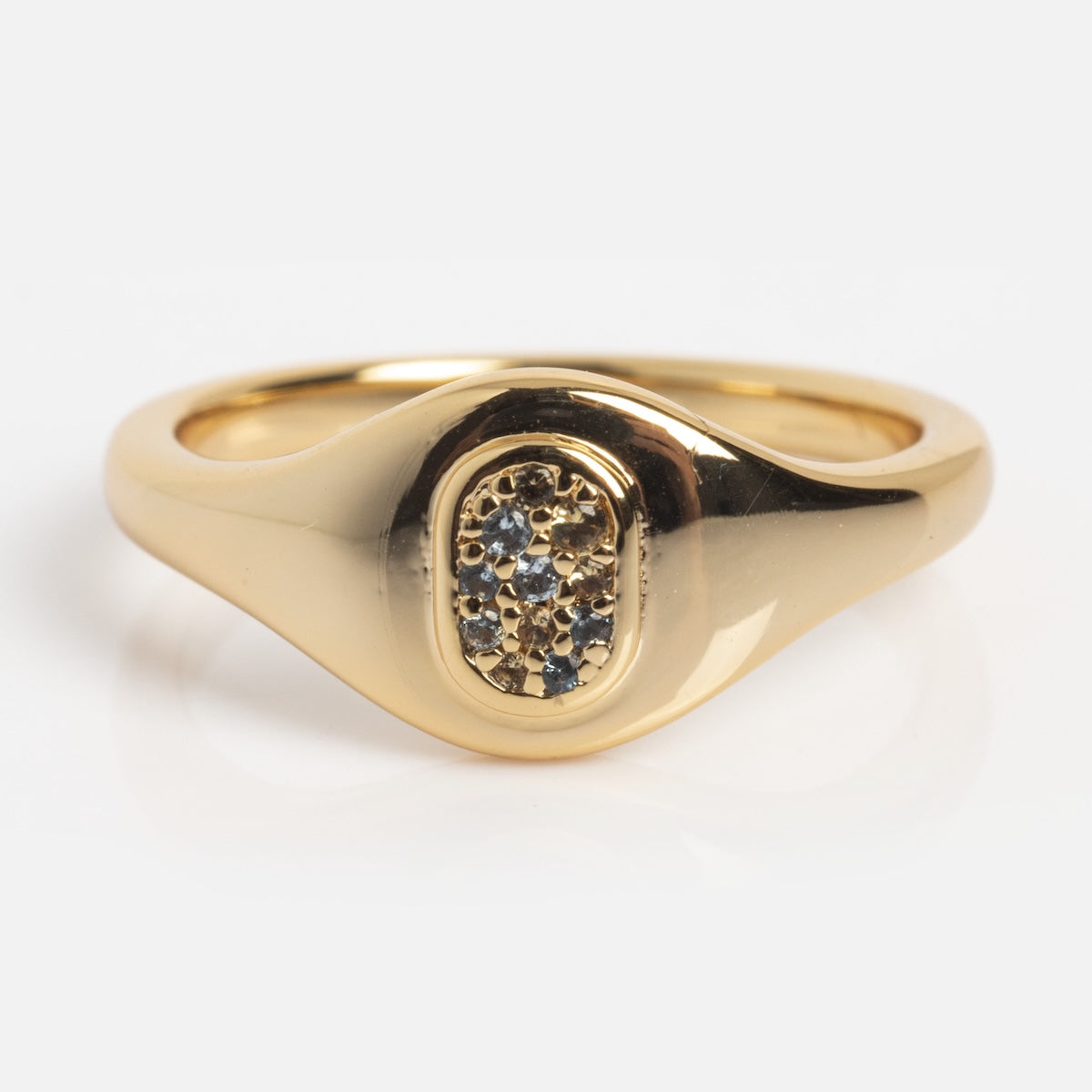 The Gemmy Signet Pinky Ring Sample Size 5 features a smooth, rounded band and an oval setting with clustered nano gemstones, elegantly crafted in 14k yellow gold plated metal and shown against a plain white background.