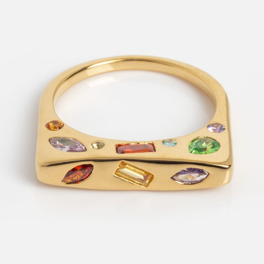 The Bold Hidden Gemstone Signet Ring (Sample Size 7) features a 14k yellow gold-plated, flat squared top set with amethyst and garnet gemstones in various shapes and sizes, displayed on a plain white background.