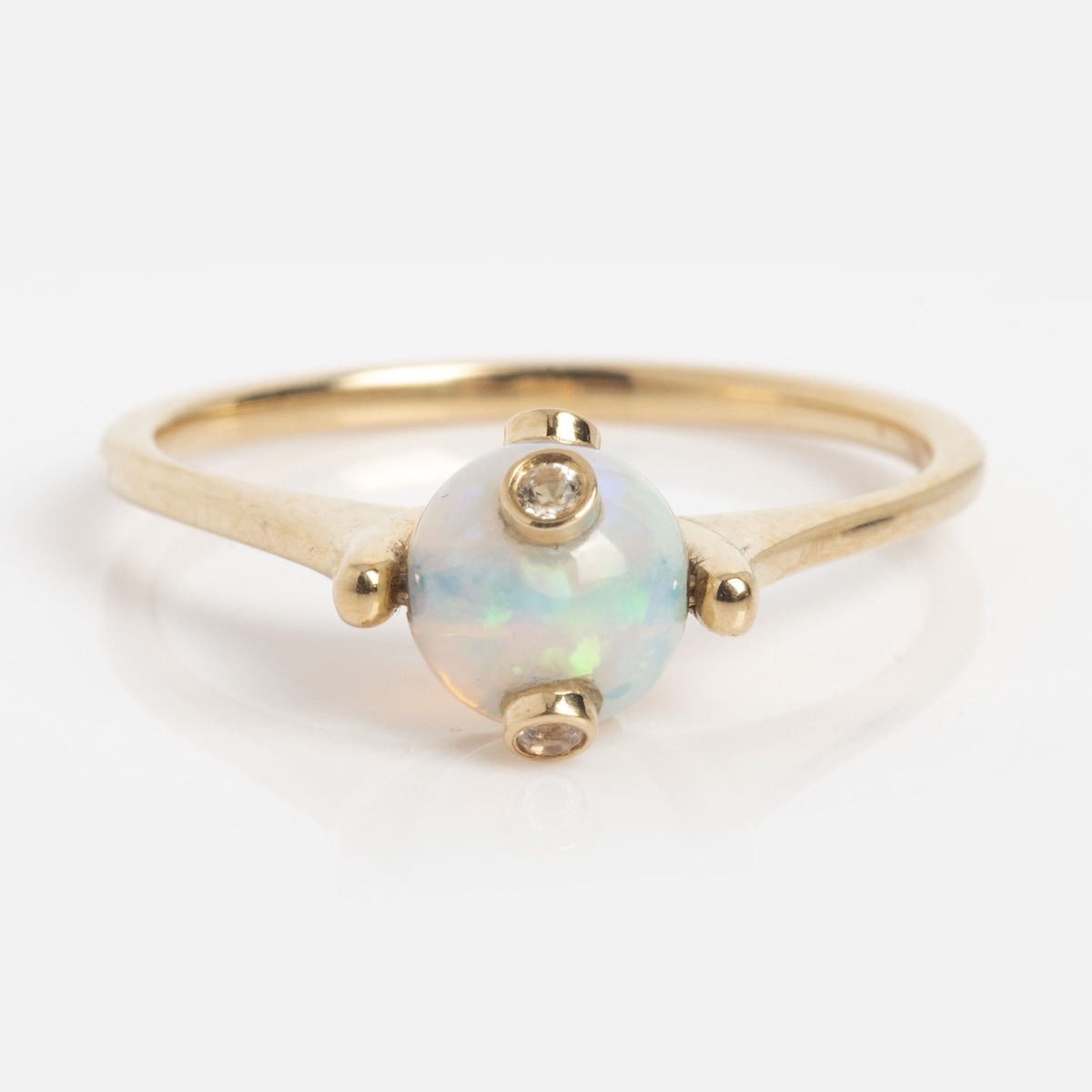 The Solid Gold Opal and Pearl Stacking Ring (Sample Size 7) features a delicate 9k yellow gold band with a round Ethiopian opal centerpiece, accented by two small round diamonds on either side.