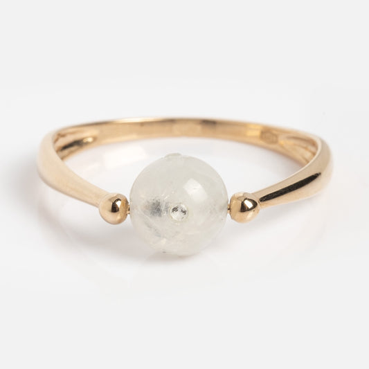 The Solid Gold Moonstone Gem Drop Ring Sample Size 7 is a 9k yellow gold ring with a round, translucent moonstone between two small gold beads on a polished band, shown on a white background.