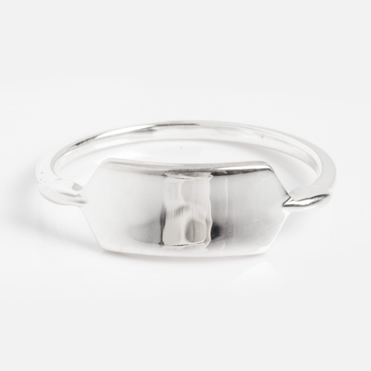 The Silver Engravable Bar Ring Sample is a minimalist silver ring with a flat, hexagonal plate at the center, shown against a plain white background.