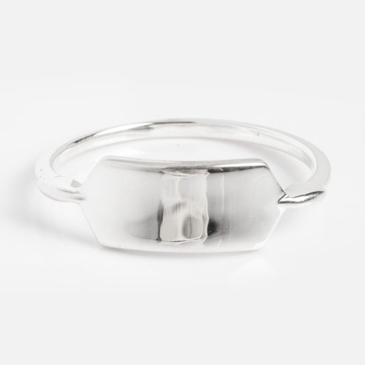 The Silver Engravable Bar Ring Sample is a minimalist silver ring with a flat, hexagonal plate at the center, shown against a plain white background.