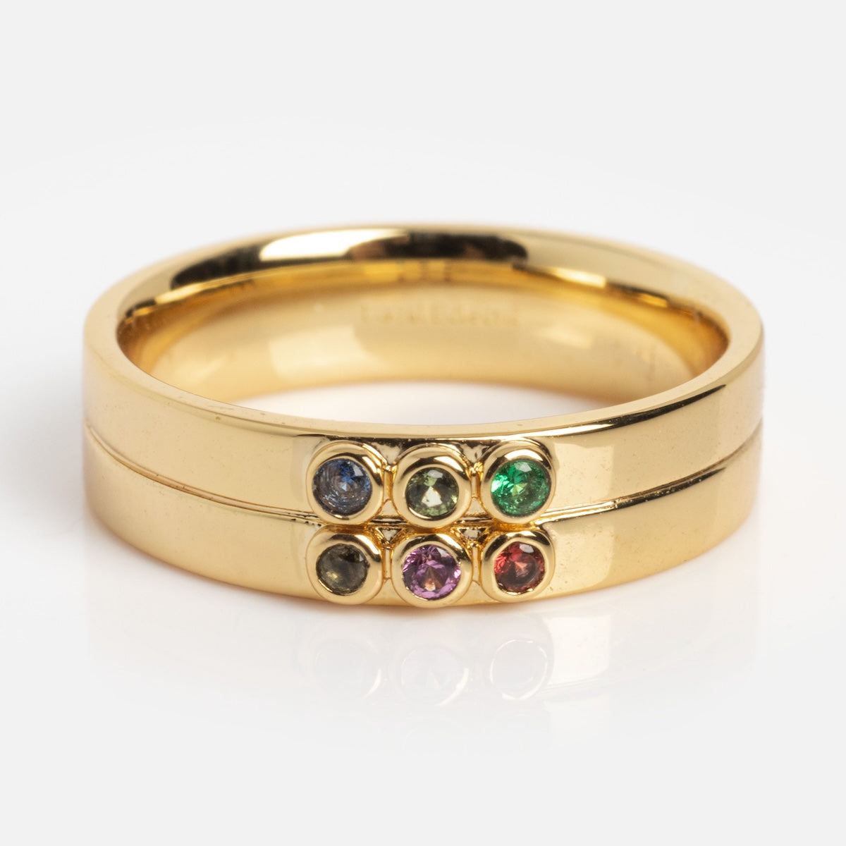 The Stacked Gem Drop Pinky Ring Sample Size 5 features two 14k yellow gold plated bands, each set with 1.5 mm gemstones—blue CZ spinel, green, black, purple, and red—stacked together against a plain white background.