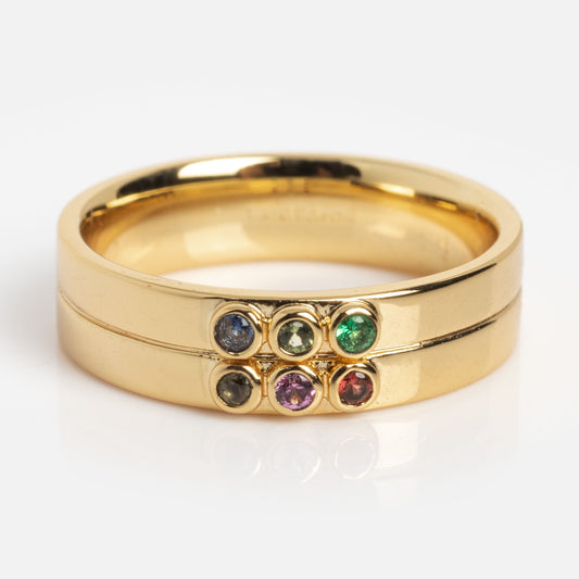 The Stacked Gem Drop Pinky Ring Sample Size 5 features two 14k yellow gold plated bands, each set with 1.5 mm gemstones—blue CZ spinel, green, black, purple, and red—stacked together against a plain white background.