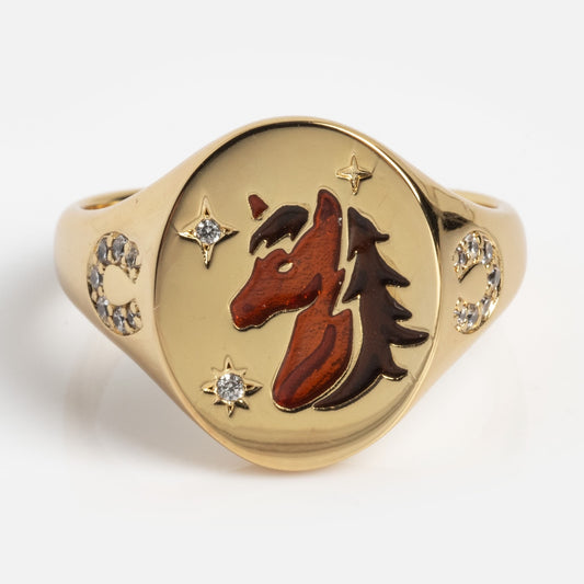 The Horse Signet Ring Sample Size 7 features a sturdy brass base plated in 14k yellow gold, with a round face engraved with a red and brown horse head beside a pine tree, accented by star, crescent moon motifs, and sparkling White CZs.