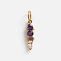 A solid gold pendant, the Solid Gold Modern Ombre Birthstone Charm showcases three vertically aligned gems—pear and round purple stones above a clear tapered rectangle—all set in gold prongs. A striking addition to any collection.