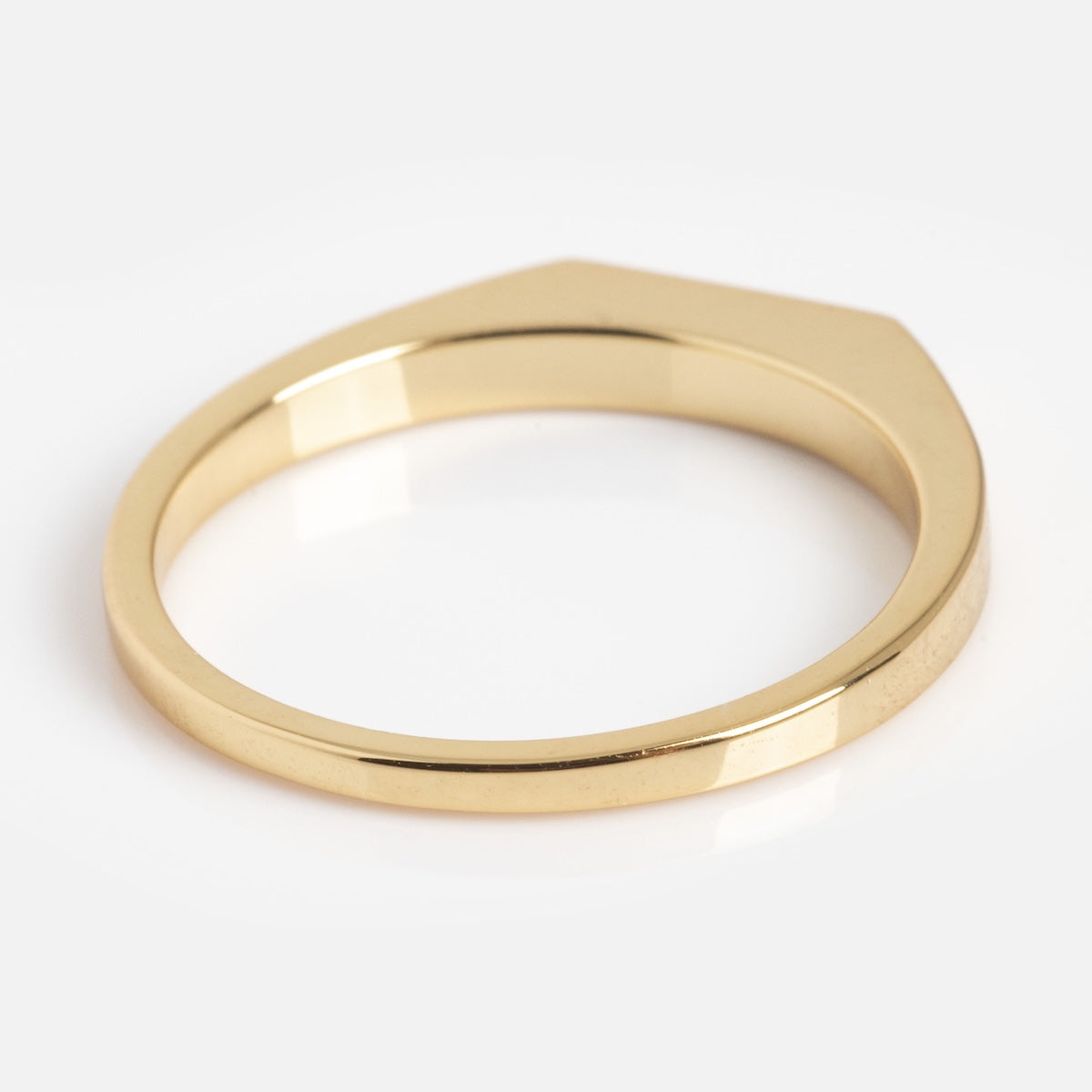 The Tiny Conversation Stacking Ring is a gold piece with a minimalist design, featuring a flat geometric top and smooth polished finish, shown against a white background.