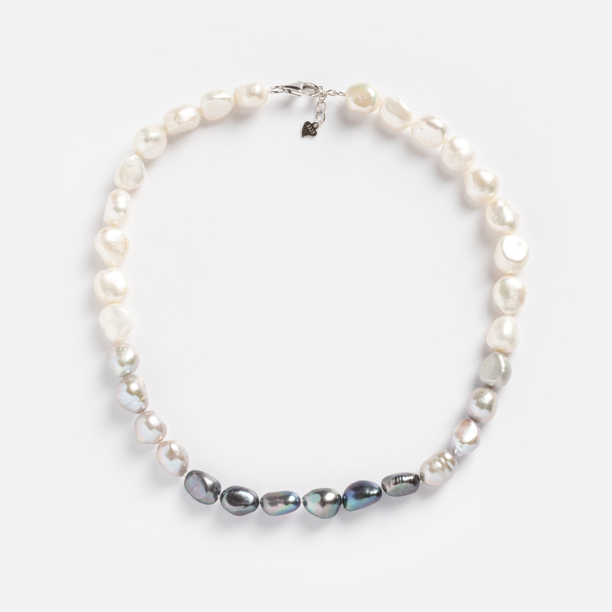 The La Fumee Necklace showcases alternating white and dark baroque freshwater pearls with a 14k gold plated clasp and charm, presented on a white background.