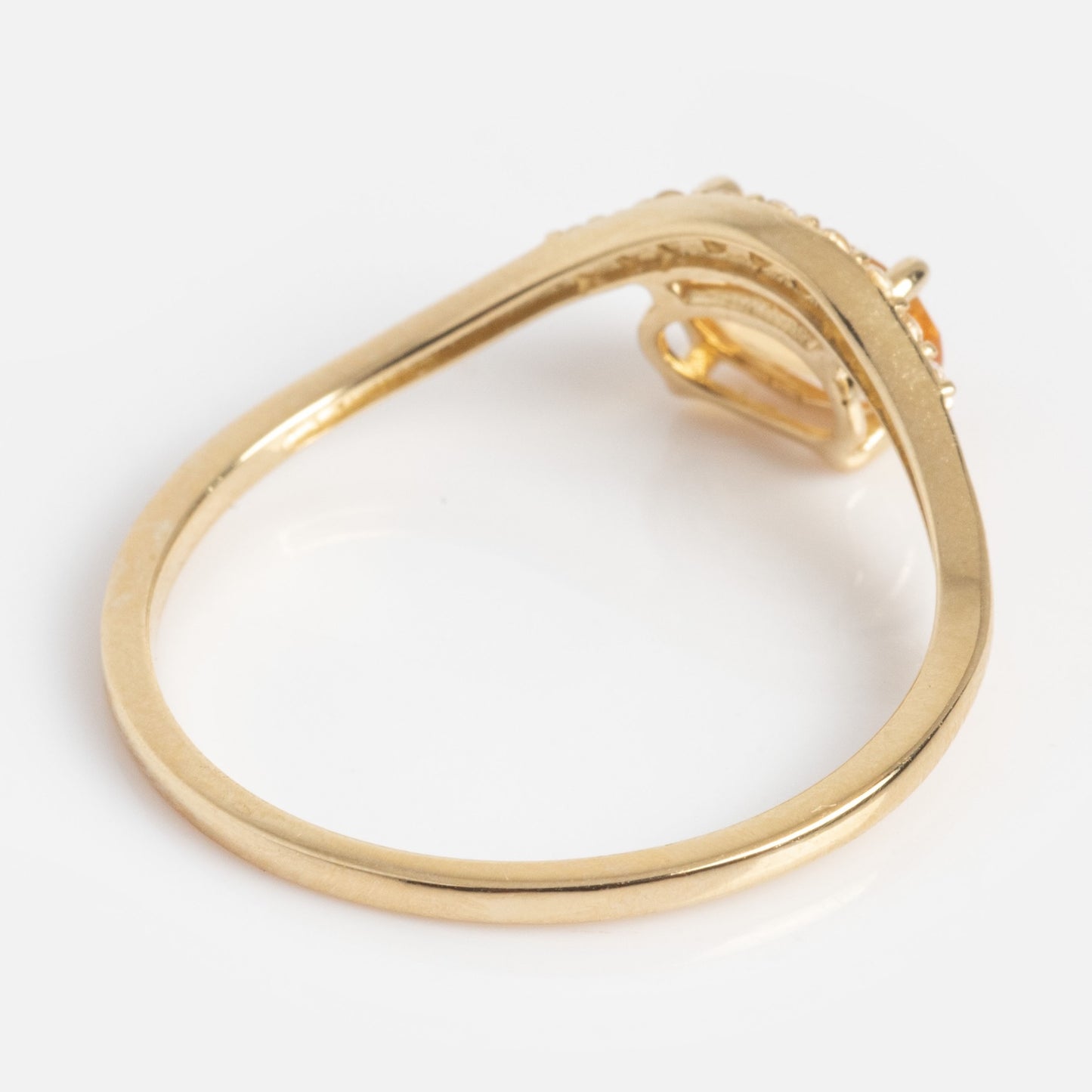 The Solid Gold 2025 November Capsule Floating Citrine Statement Ring features an asymmetrical twisted band and a citrine gemstone setting, displayed from the side against a plain white background.