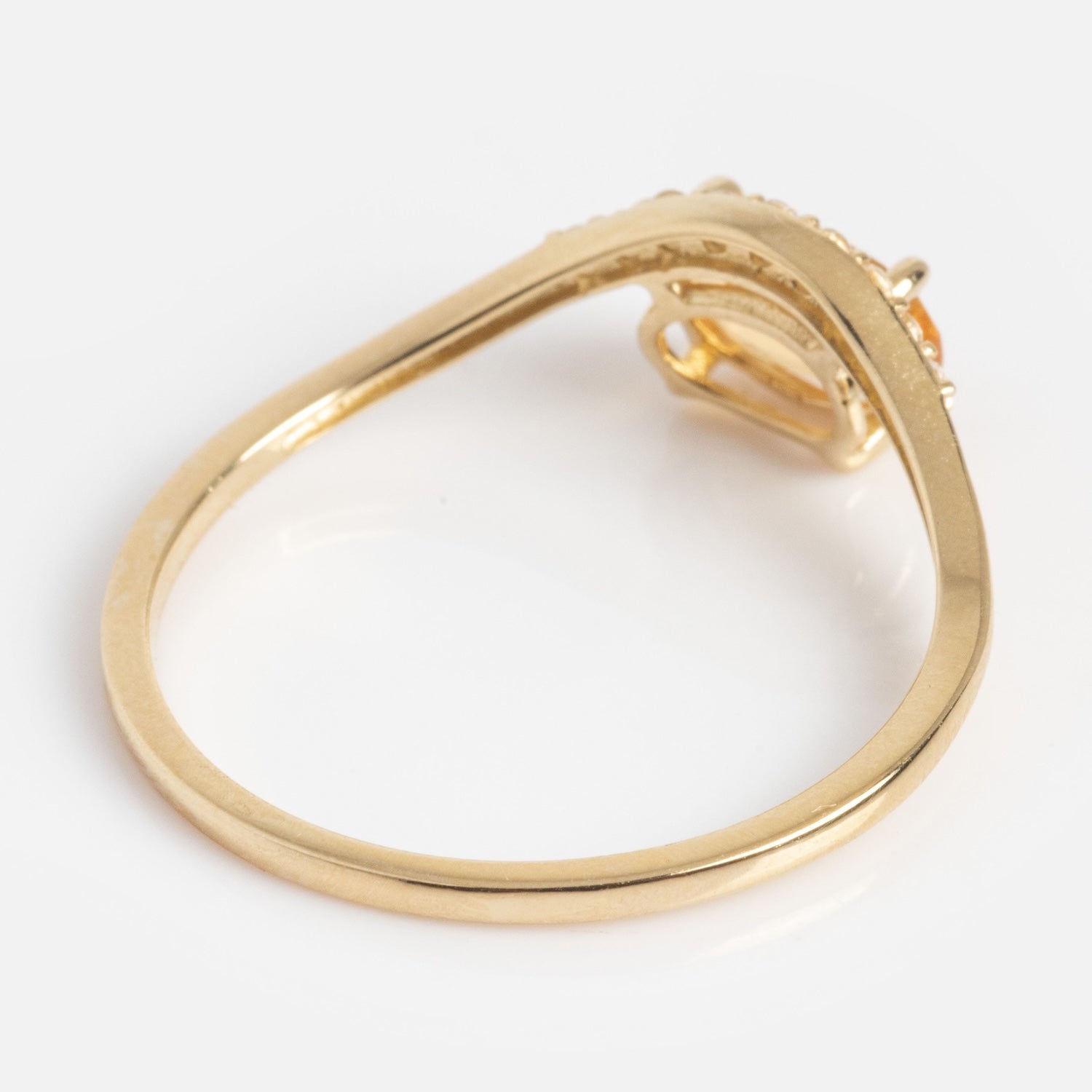 The Solid Gold 2025 November Capsule Floating Citrine Statement Ring features an asymmetrical twisted band and a citrine gemstone setting, displayed from the side against a plain white background.