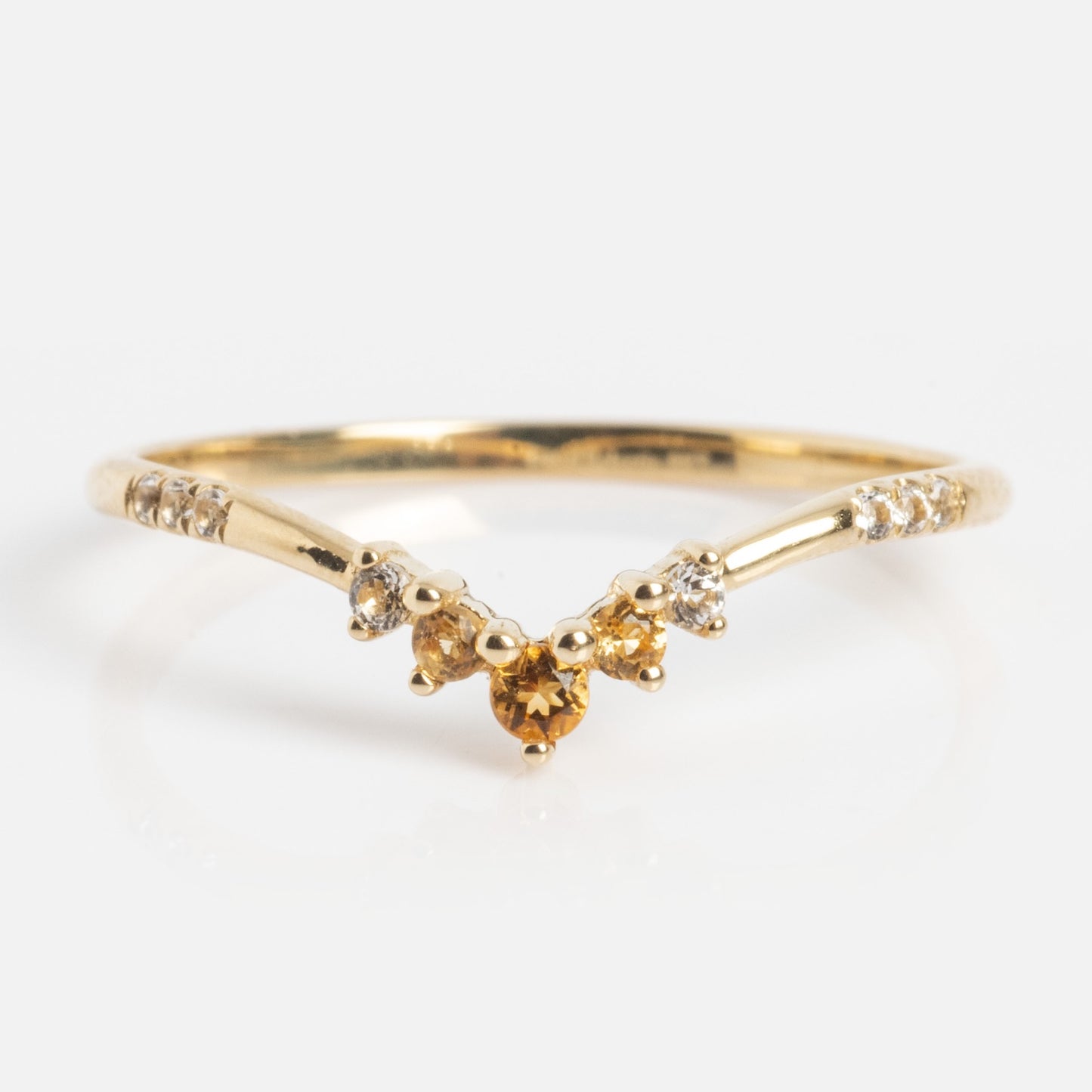 The Solid Gold 2025 November Capsule Delicate Arch Citrine Stacking Ring features a central citrine gemstone, flanked by two smaller citrines and two clear stones on each side along the band.