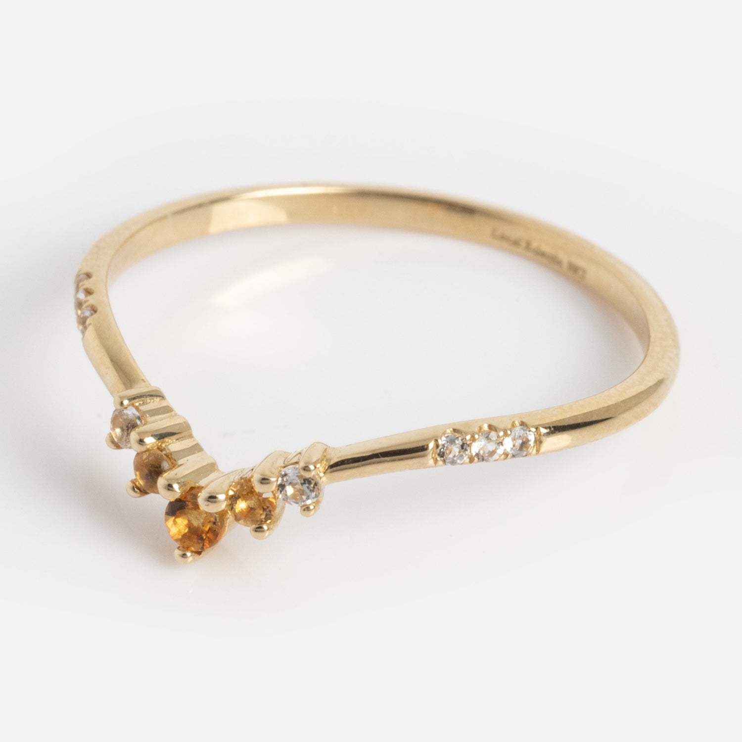 The Solid Gold 2025 November Capsule Delicate Arch Citrine Stacking Ring features a gentle gold curve with small white diamonds and a central citrine gemstone, set on a plain gold band against a white background.