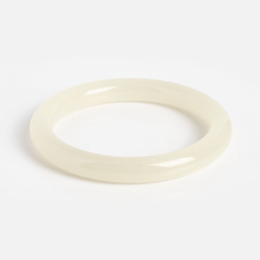 The 1994 Off White Thin Jade Bangle is a glossy, off-white round bangle with a smooth surface, expertly crafted from natural jade and shown on a plain white background.