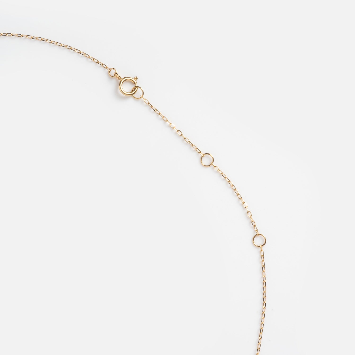 The Solid Gold 2025 December Capsule Classic Tanzanite Pendant Necklace features a delicate gold chain with three small circular loops and a spring ring clasp, elegantly displayed on a plain white background.