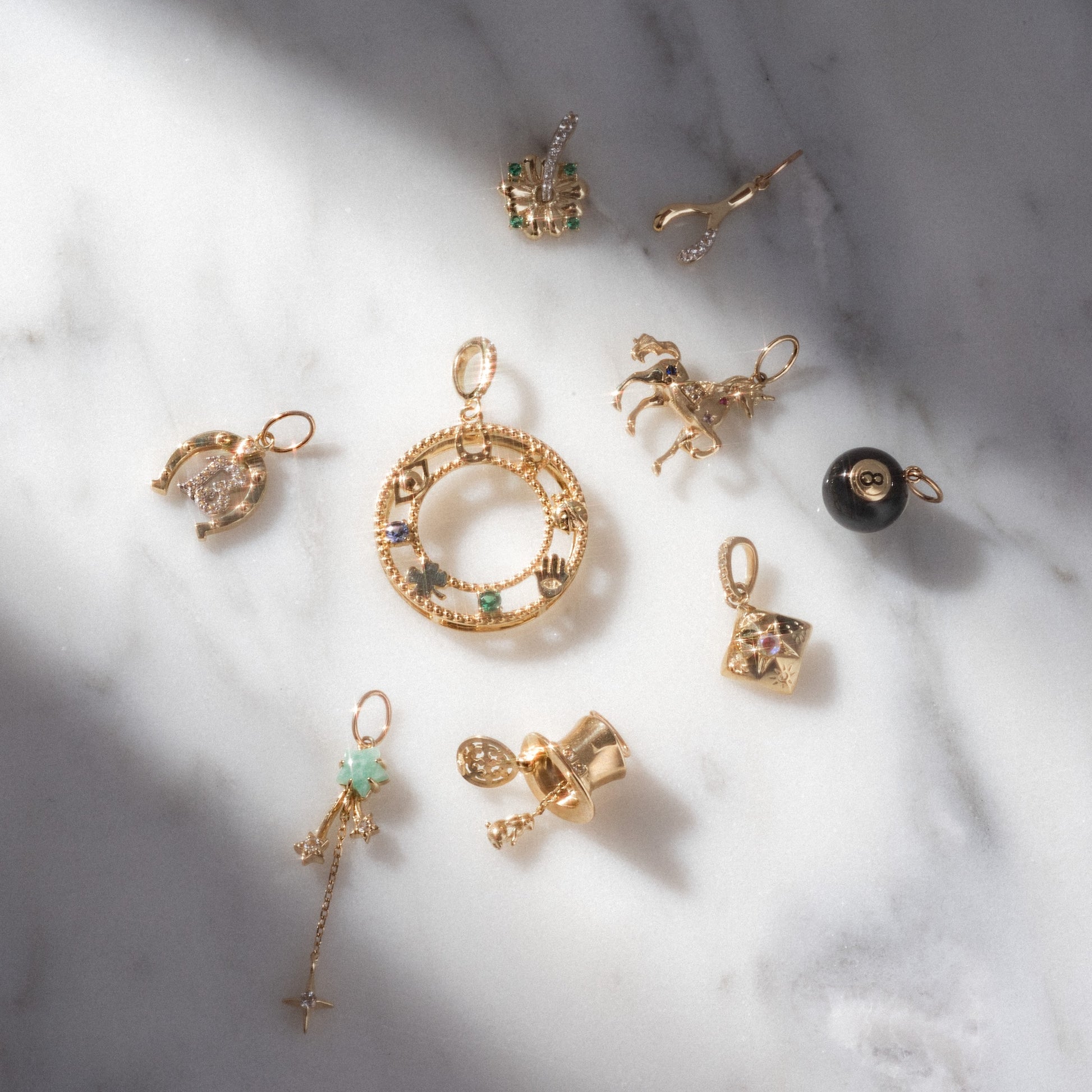 Gold jewelry pendants on a marble surface