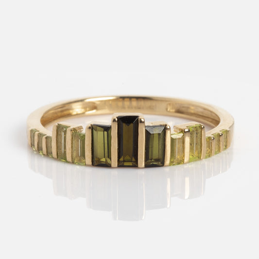 The 10k Green Tourmaline Skyline Band, a gold ring with a row of graduated rectangular green gemstones, is displayed against a white background.