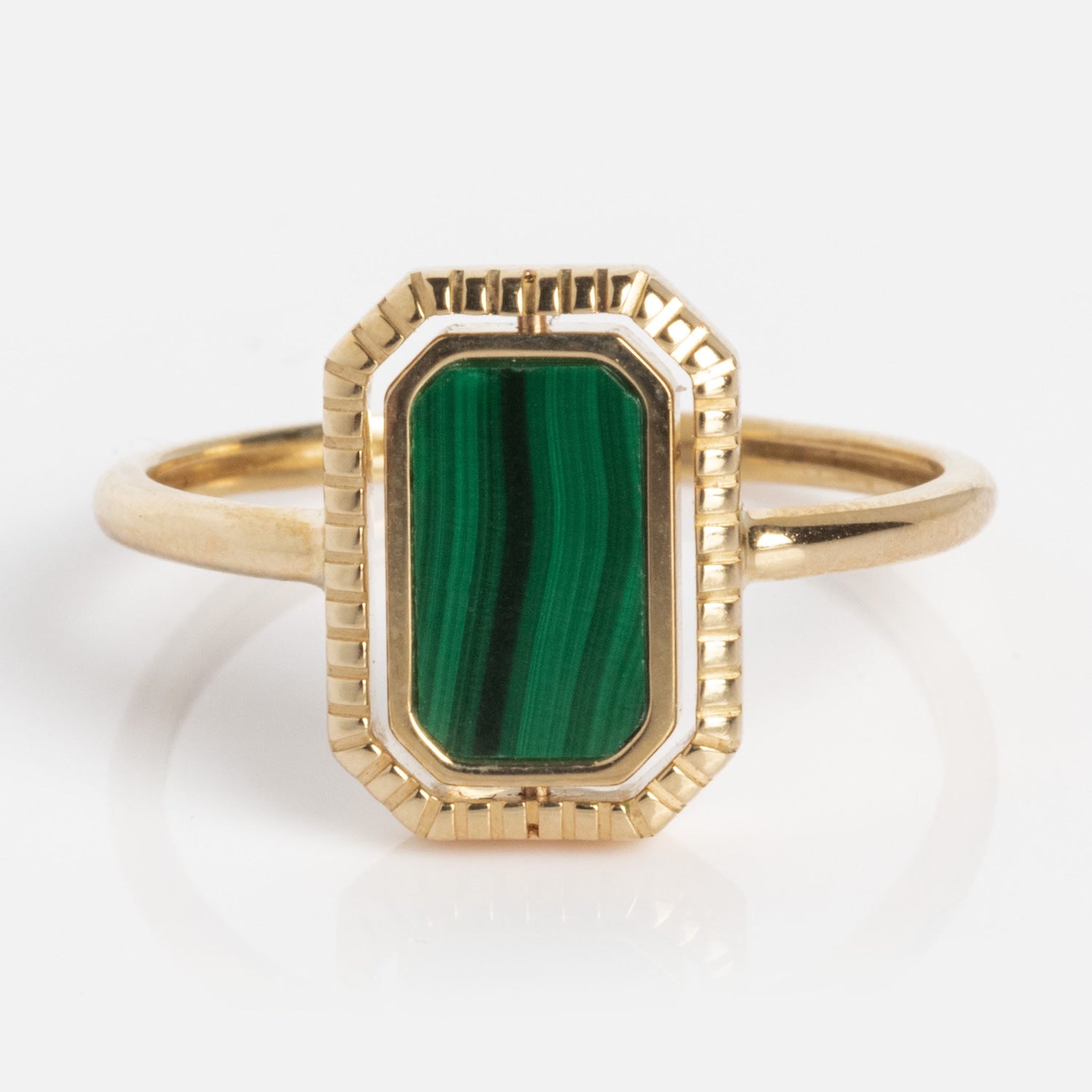 The 10k Gallery Frames Enamel and Malachite Reversible Ring showcases a rectangular, vertically striped green malachite stone in a geometric bezel setting, captured against a plain white background.