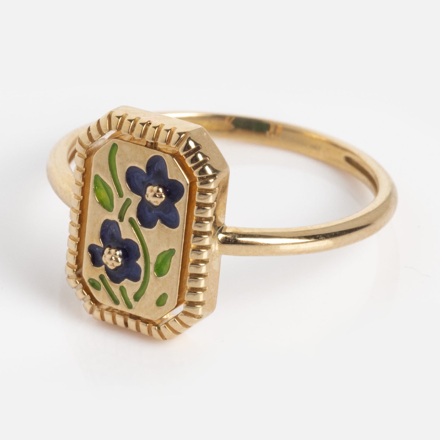 The 10k Gallery Frames Enamel and Malachite Reversible Ring features a rectangular gold face with two purple enamel flowers, yellow centers, green leaves, and a ridged gold border.