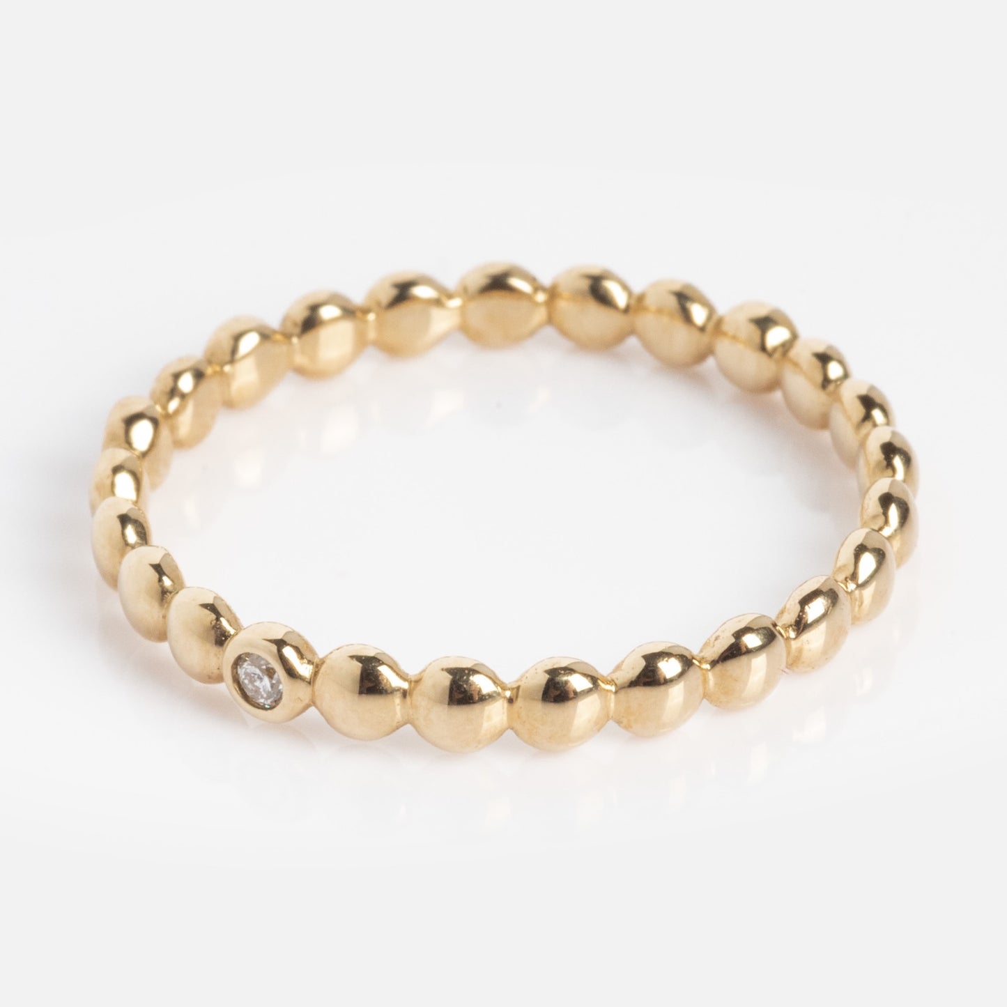 The 10k Hidden Message Morse Code Diamond Band features a thin gold band with round, polished beads and a small diamond set in one bead, shown on a white background.