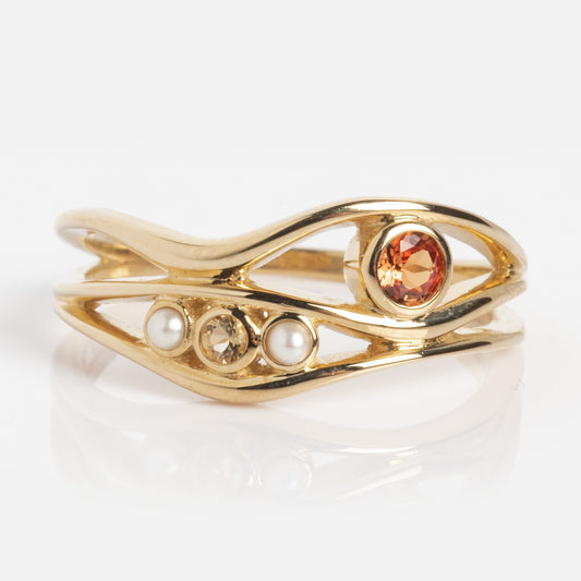 The 10k Orange Sapphire and Citrine Bayside Ring features an open, wavy gold band adorned with one orange gemstone and two small white pearls.