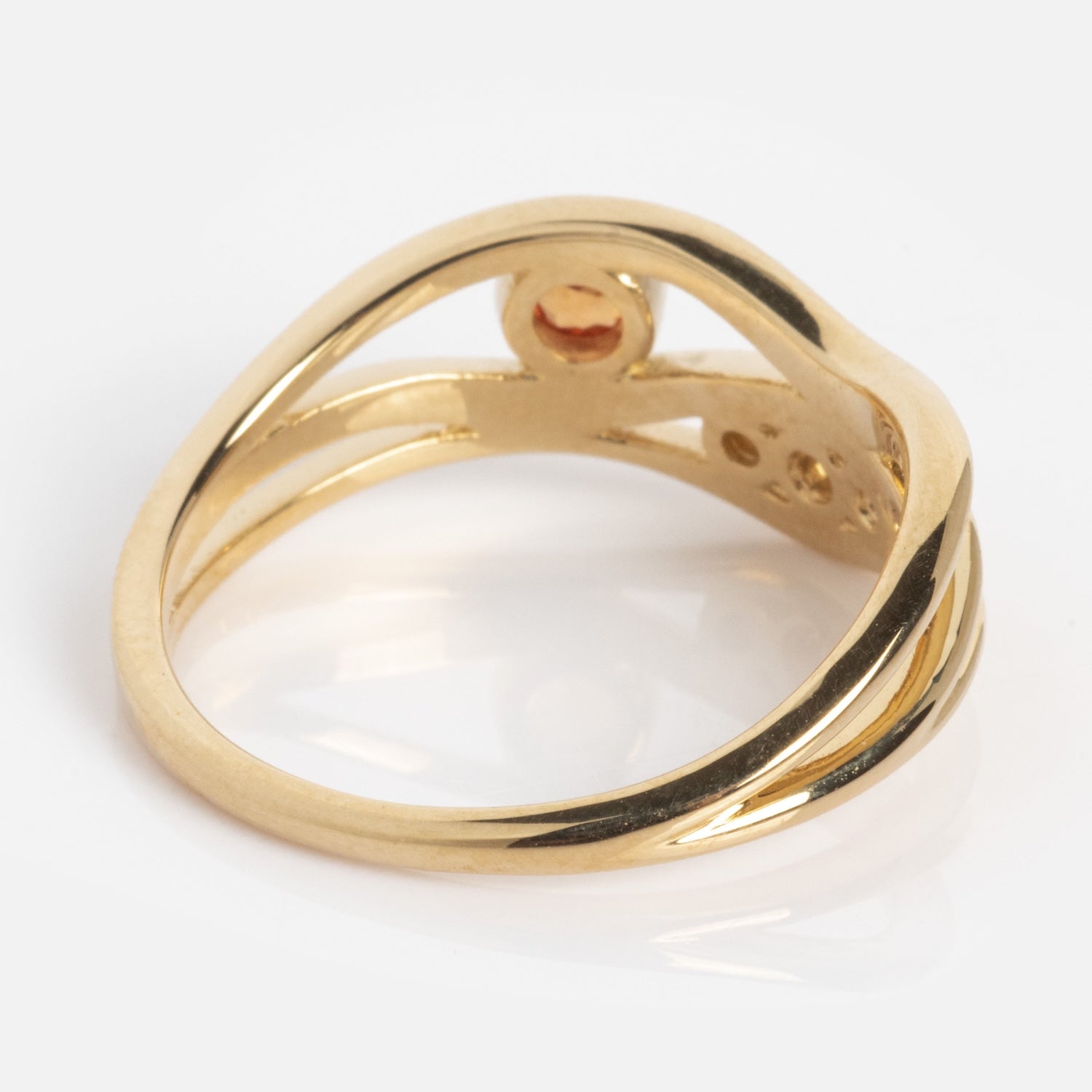 The 10k Orange Sapphire and Citrine Bayside Ring features a twisted, open shank design with a smooth, polished finish and a small circular setting, as seen from the underside.