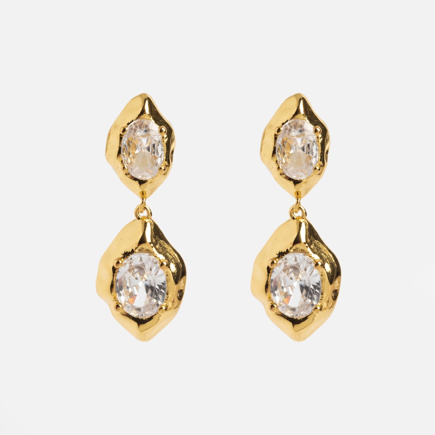 The Lowell Earrings feature gold drop designs with two irregular, textured settings holding clear oval gemstones, presented against a plain white background.
