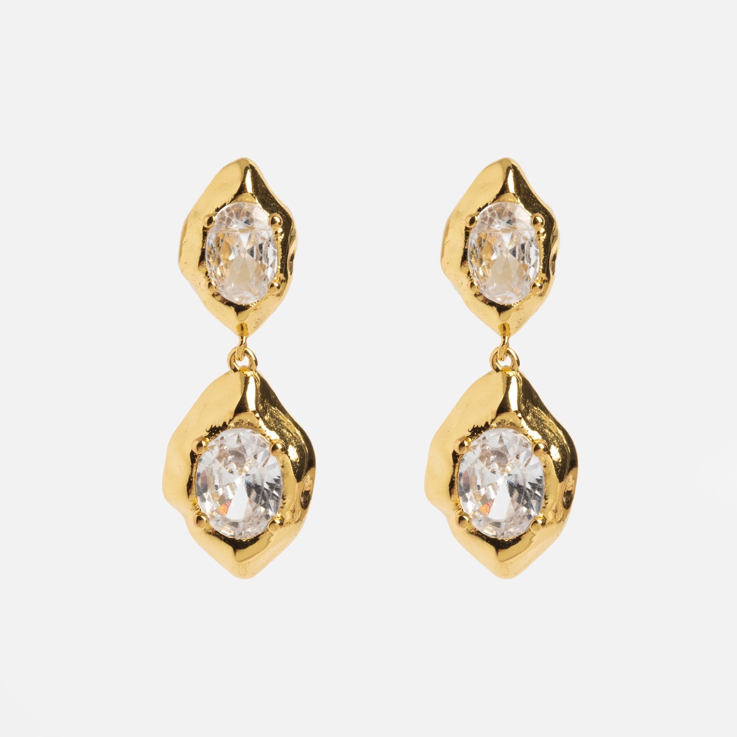 The Lowell Earrings feature gold drop designs with two irregular, textured settings holding clear oval gemstones, presented against a plain white background.
