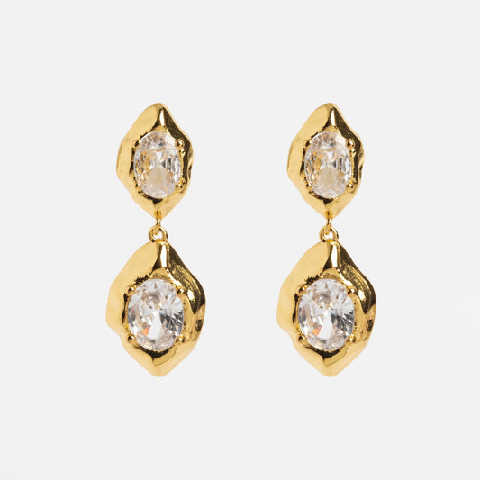 The Lowell Earrings feature gold drop designs with two irregular, textured settings holding clear oval gemstones, presented against a plain white background.