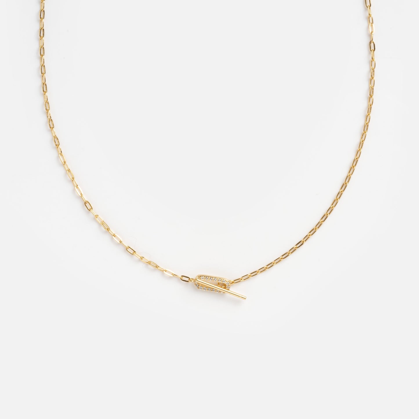 The Jade Pave Necklace features a delicate gold chain with a small, horizontal feather-shaped pendant at the center, displayed on a plain white background.