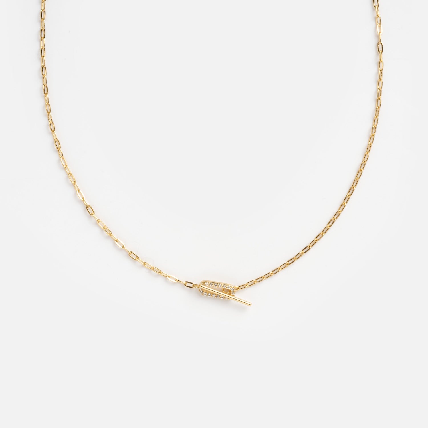 The Jade Pave Necklace features a delicate gold chain with a small, horizontal feather-shaped pendant at the center, displayed on a plain white background.
