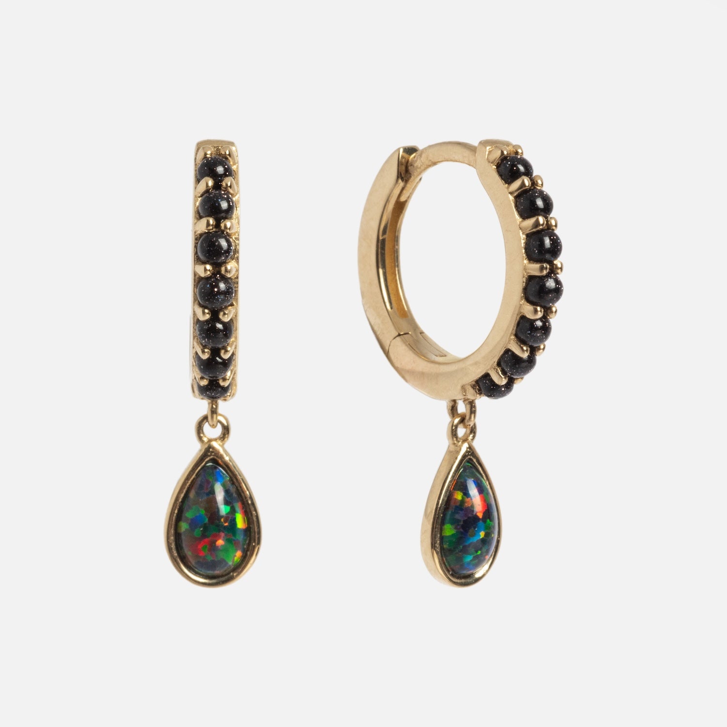 The Solid Gold Black Opal Galaxy Droplet Huggie Hoops feature gold hoops with black opals and teardrop-shaped, multicolored gemstone pendants, shown on a white background.