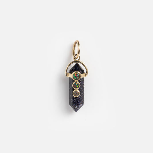 Exclusive to Local Eclectic, the Solid Gold Amulet Charm features a dark pointed crystal with three small round multicolored gemstones set vertically above it, all displayed on a plain white background.