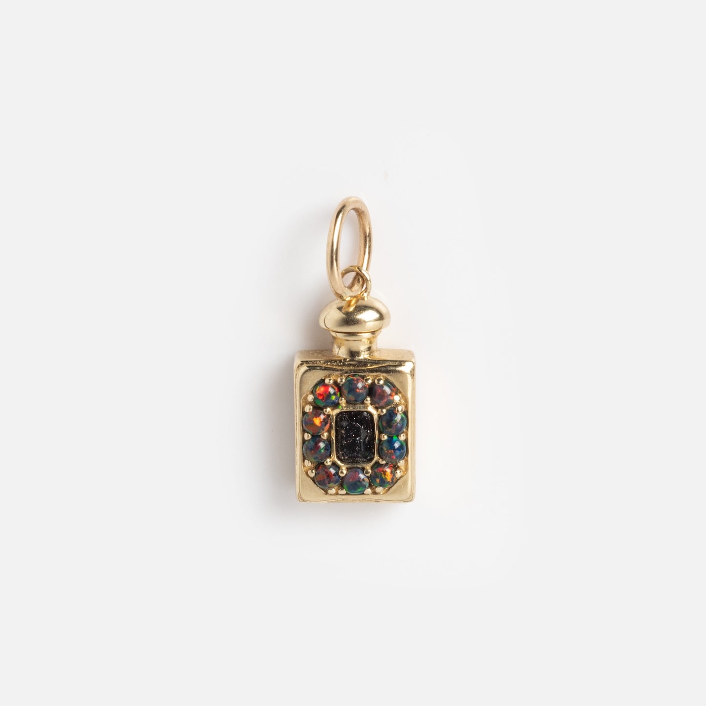 The Solid Gold Amulet Charm, exclusive to Local Eclectic, is shaped like a small bottle with a central black stone, colorful gemstones, and a round top loop—shown on a plain white background.