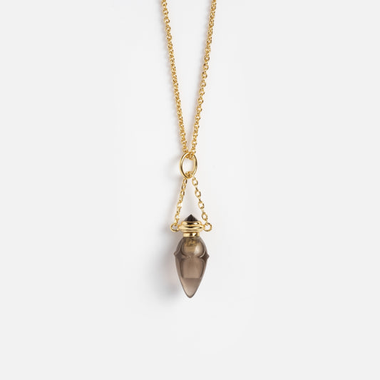 The Shadow Realm Vial Necklace is a gold chain necklace with a pendant featuring a pointed, translucent brown stone, secured by a gold cap and bale, shown on a plain white background.