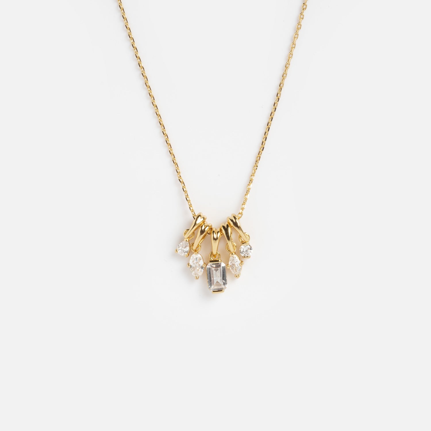 The Shades of You Ombre Birthstone Charm Necklace features a delicate gold chain with five clear gemstones—a central rectangular stone and four round stones—arranged in a symmetrical cluster at the center.