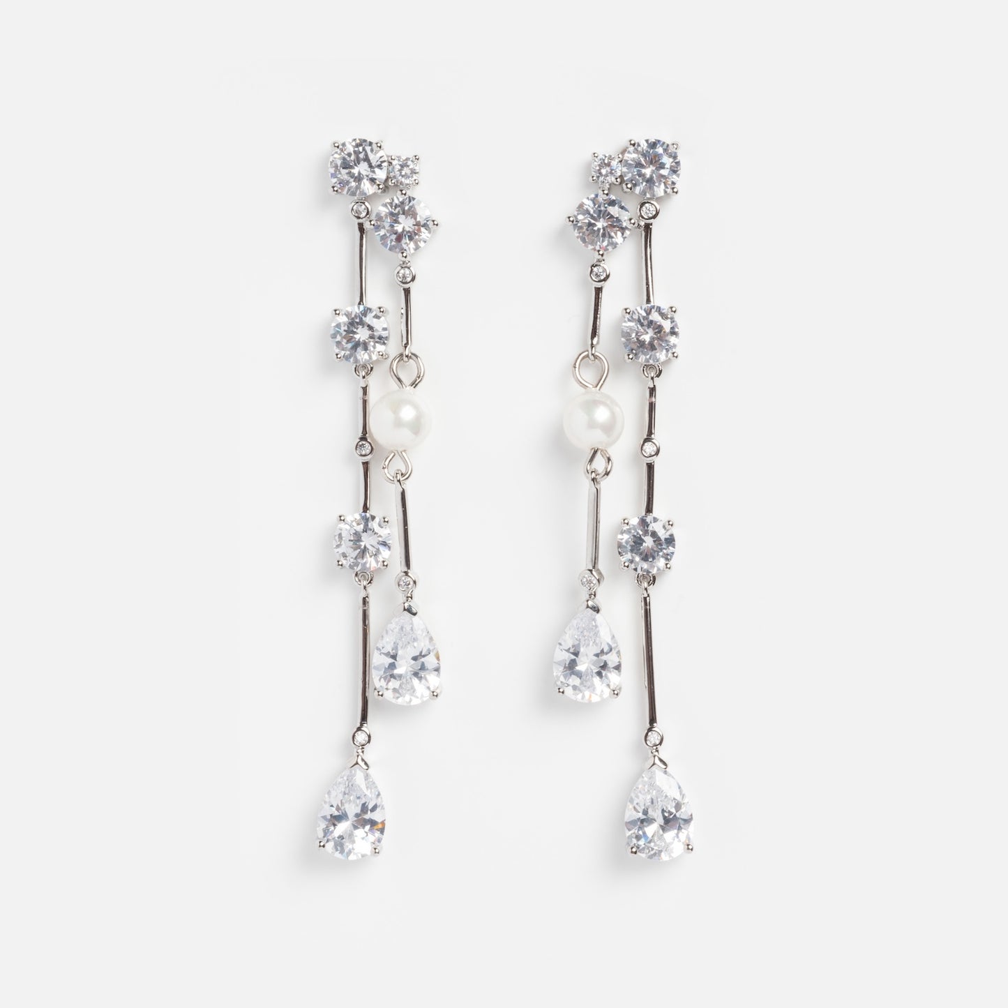 Jones Diamond Drop Earrings Sample: Elegant silver-plated drop earrings with sparkling clear gemstones and Swarovski pearls on slim silver bars with multiple dangling stones, displayed on a white background.