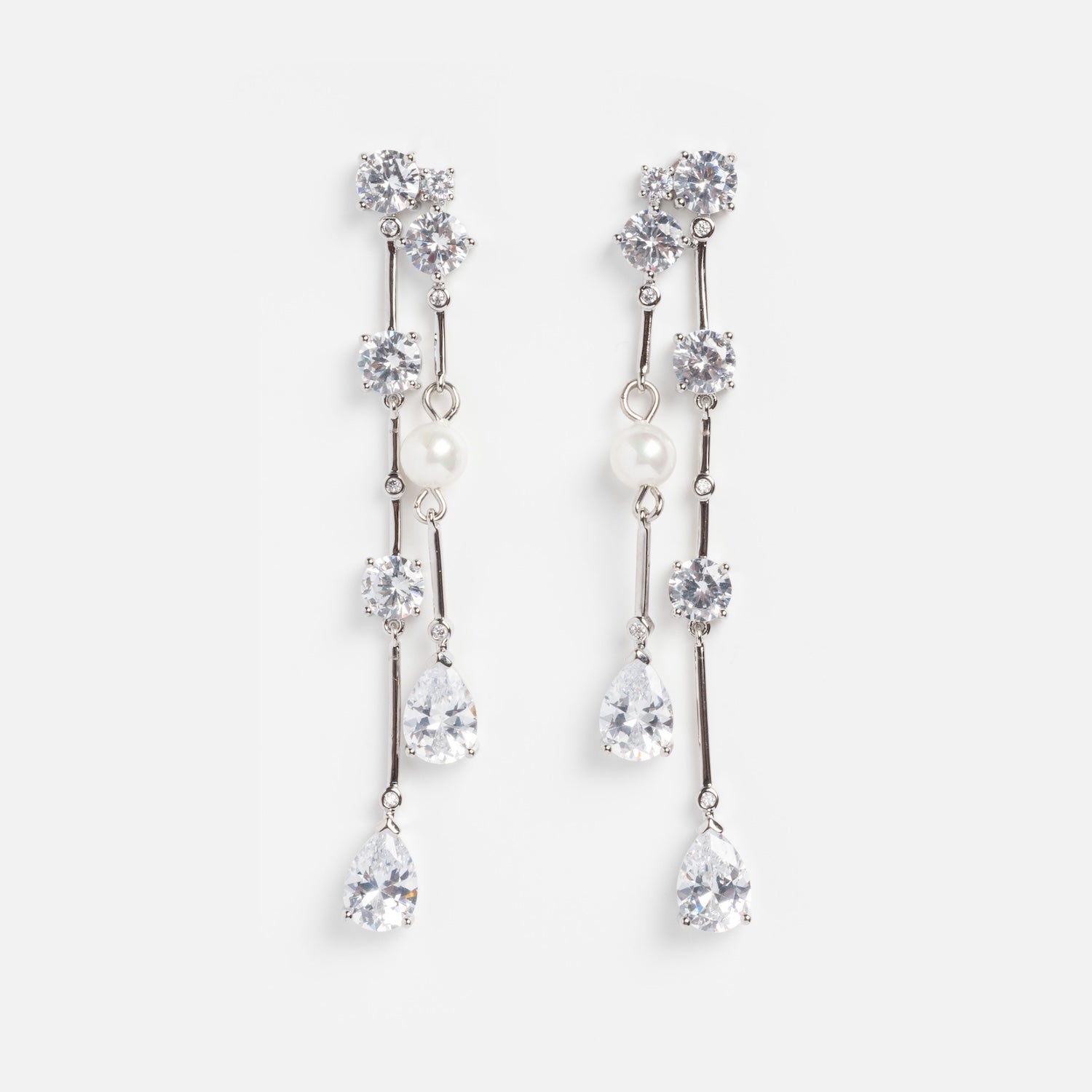 Jones Diamond Drop Earrings Sample: Elegant silver-plated drop earrings with sparkling clear gemstones and Swarovski pearls on slim silver bars with multiple dangling stones, displayed on a white background.