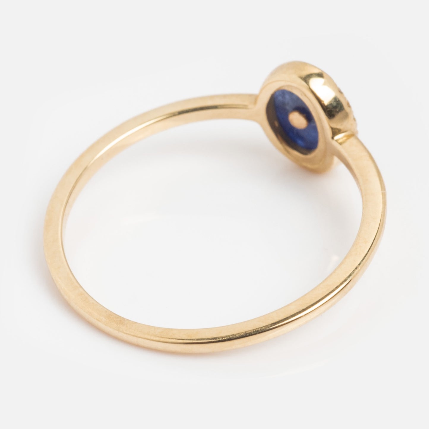 The Solid Gold Crystal Crescent Moon Ring for Manifestation features a thin gold band with a round blue gemstone in a bezel setting, shown from an angled side view against a white background.