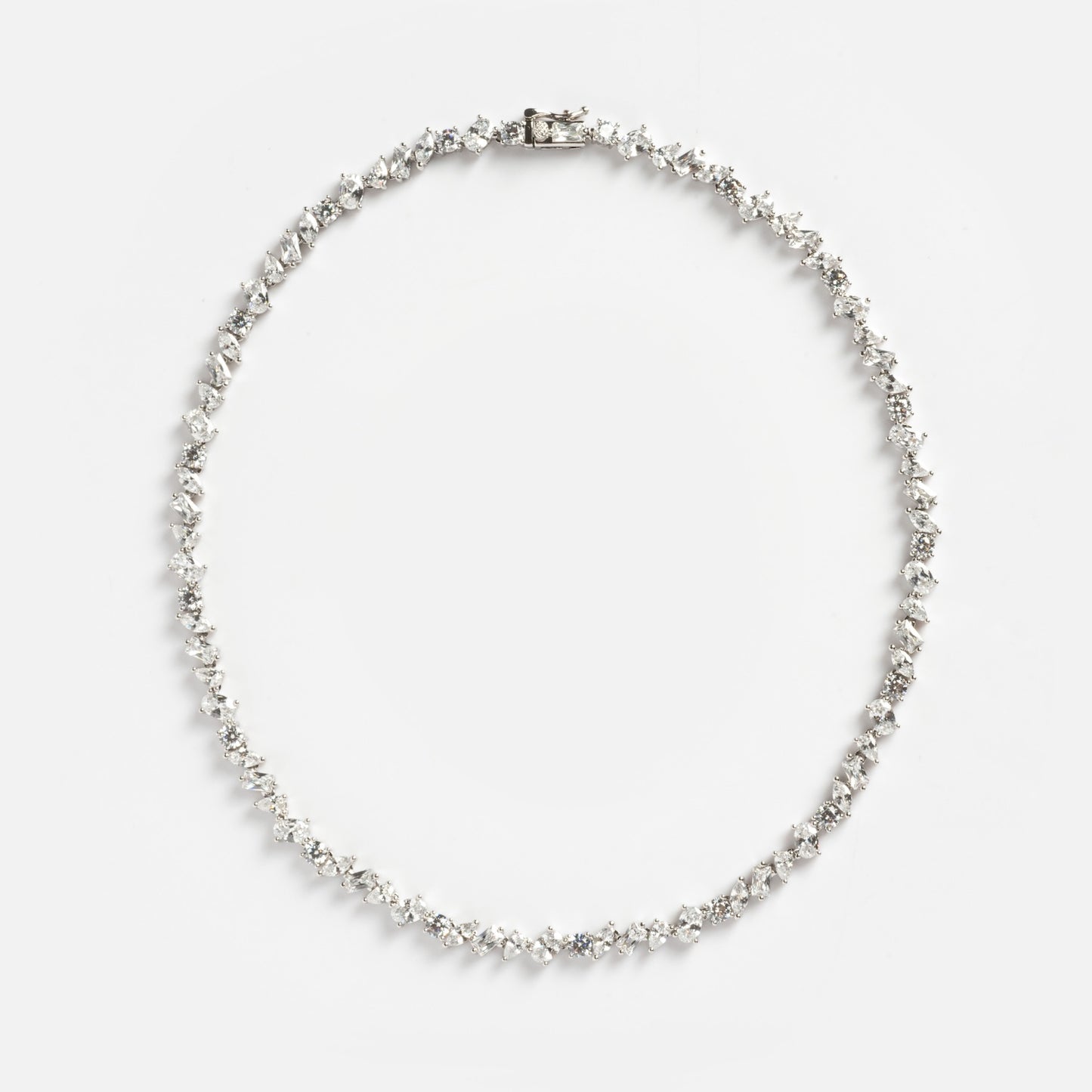 The Pear Diamond Tennis Necklace features pear-shaped diamonds set in a symmetrical row on a white metal chain, shown in a circular arrangement against a plain white background.