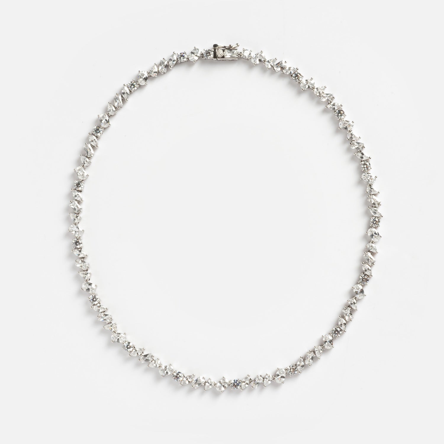 The Pear Diamond Tennis Necklace features pear-shaped diamonds set in a symmetrical row on a white metal chain, shown in a circular arrangement against a plain white background.