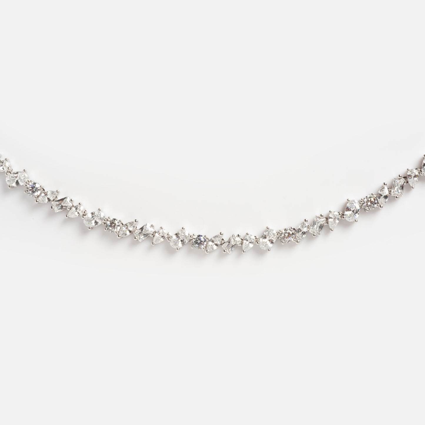 The Pear Diamond Tennis Necklace features a delicate white gold chain set with a continuous row of sparkling round and marquise-cut diamonds, elegantly displayed against a plain white background.