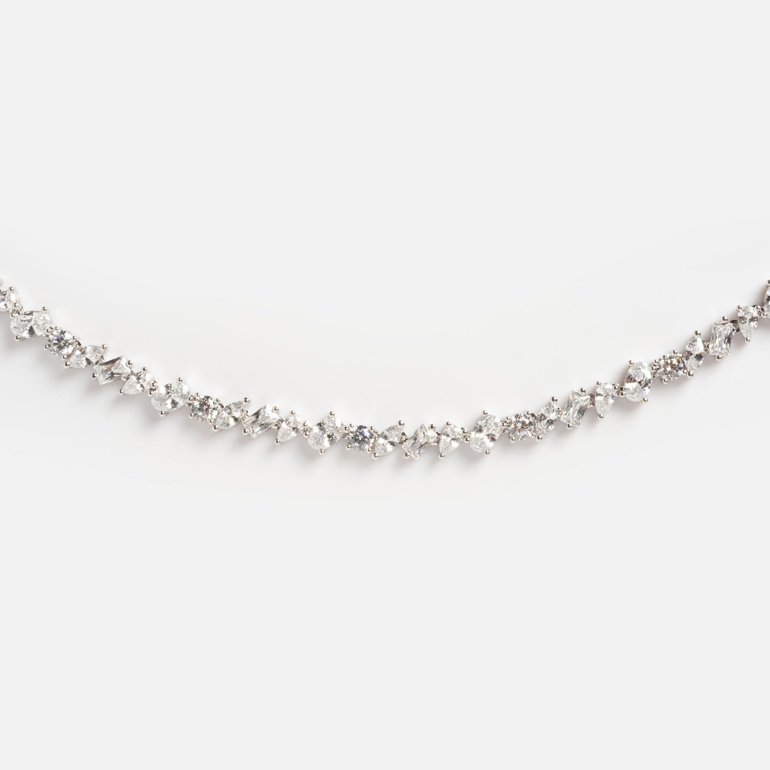 The Pear Diamond Tennis Necklace features a delicate white gold chain set with a continuous row of sparkling round and marquise-cut diamonds, elegantly displayed against a plain white background.