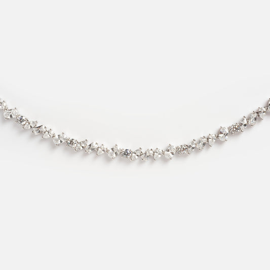 The Pear Diamond Tennis Necklace features a delicate white gold chain set with a continuous row of sparkling round and marquise-cut diamonds, elegantly displayed against a plain white background.