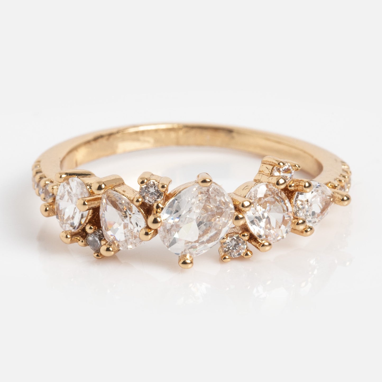 The Statement Crystal Cluster Ring features five clear gemstones in assorted shapes and sizes, accented with small round diamonds, shown against a plain white background.