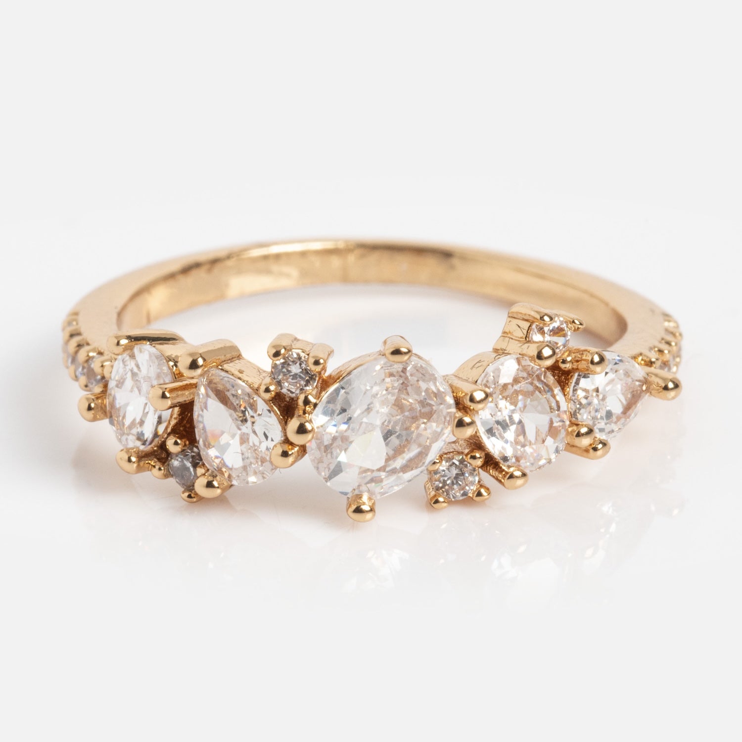 The Statement Crystal Cluster Ring features five clear gemstones in assorted shapes and sizes, accented with small round diamonds, shown against a plain white background.