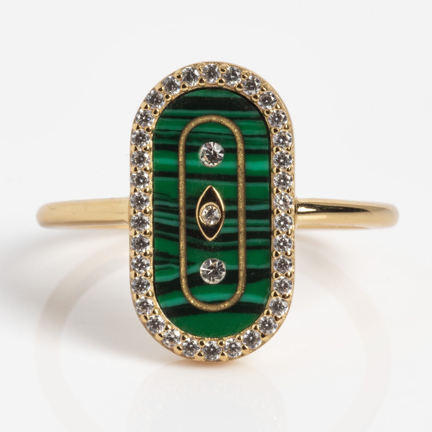 The So Art Deco Cocktail Ring is a gold ring with an oval green malachite inlay, three embedded diamonds, gold accents, and a border of small clear gemstones.